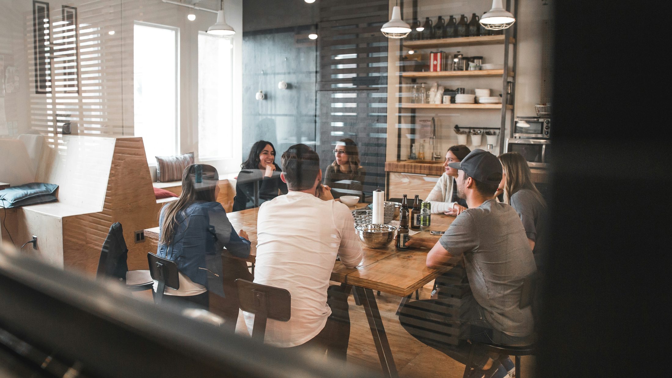 Owners and customers gathered around a table at a local spot